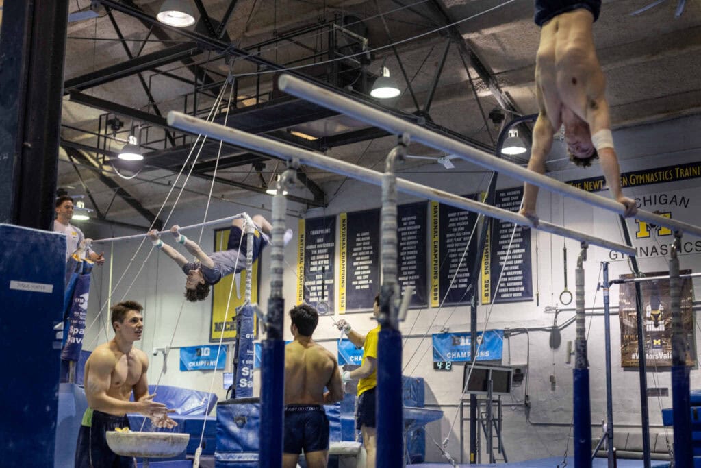 Gymnasts practice on various apparatuses.