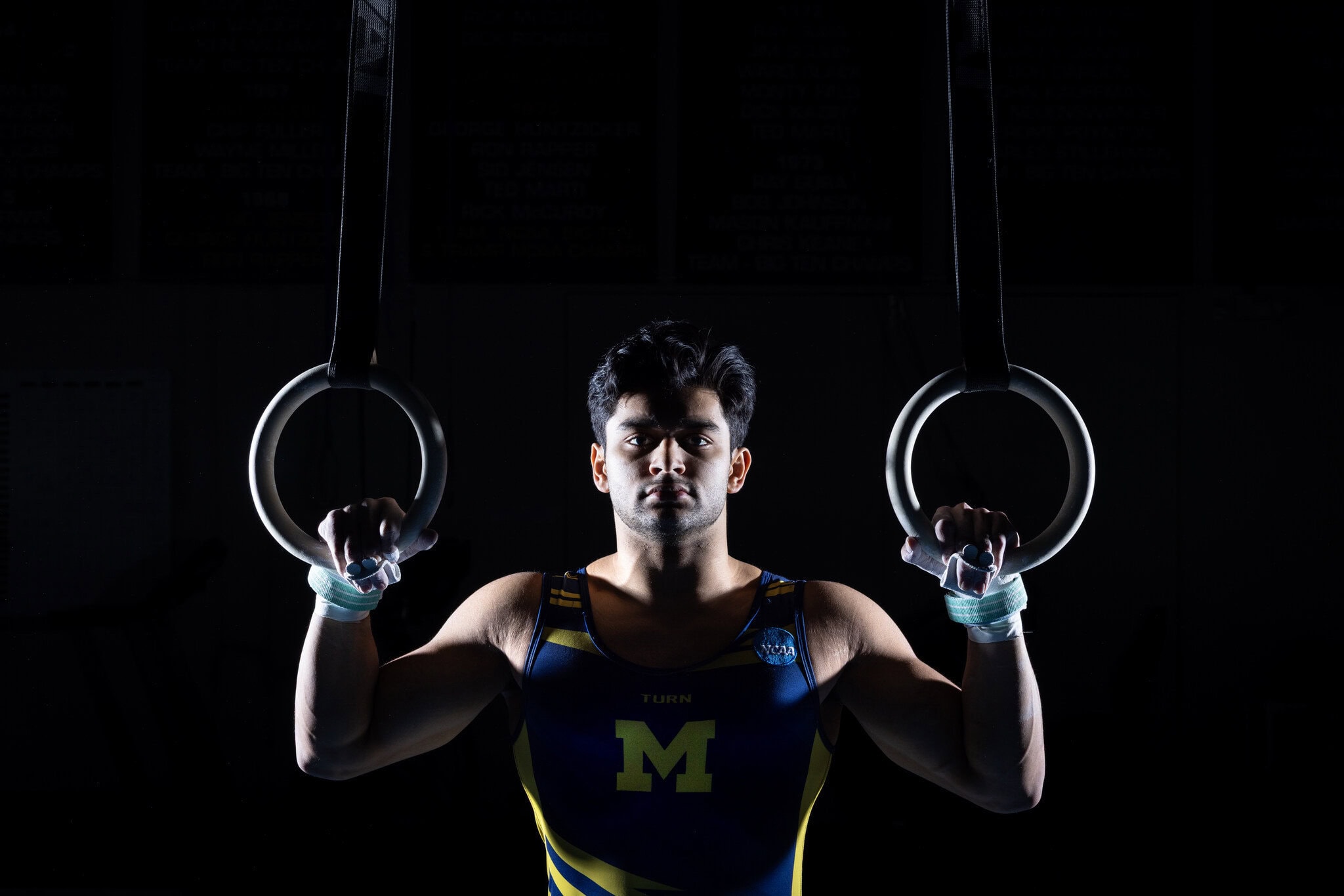 Gymnast stands holding still rings